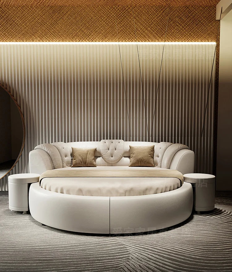 A modern, cream-coloured round double bed with a tufted headboard and matching side tables.