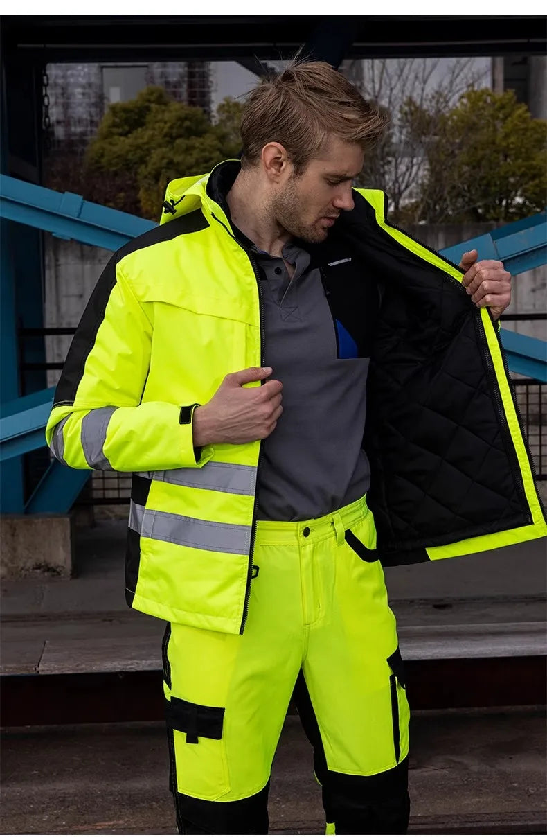A man wearing a neon yellow and black 3-in-1 waterproof hi-vis jacket and trousers set with reflective strips.