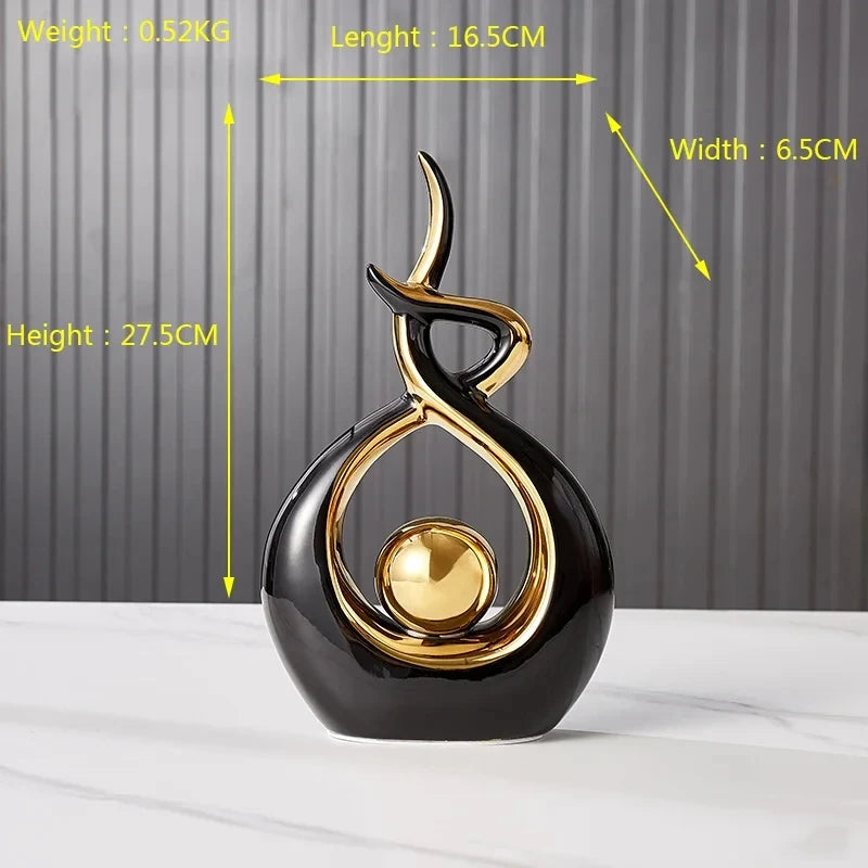 Abstract Nordic ceramic figurine in glossy black and gold, featuring an elegant, flowing silhouette with a central orb.