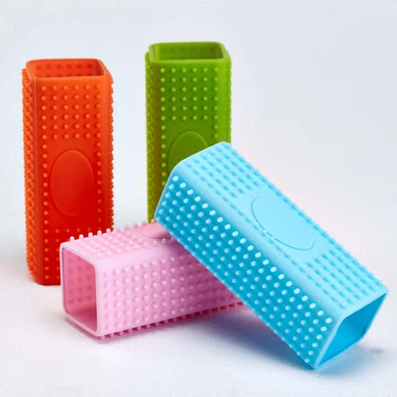 Four rectangular silicone pet hair removers in orange, green, blue, and pink, each with a textured, studded surface.
