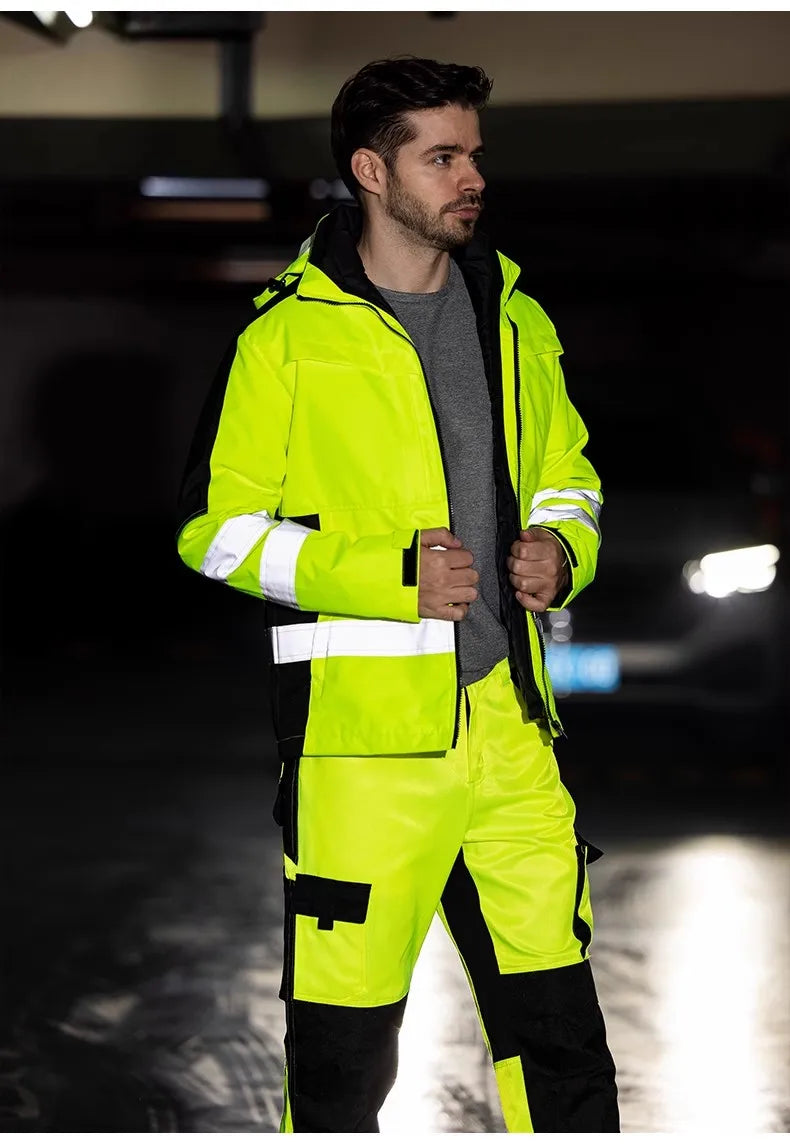 A man wearing a neon yellow and black 3-in-1 waterproof high-vis jacket and trousers set with reflective strips.
