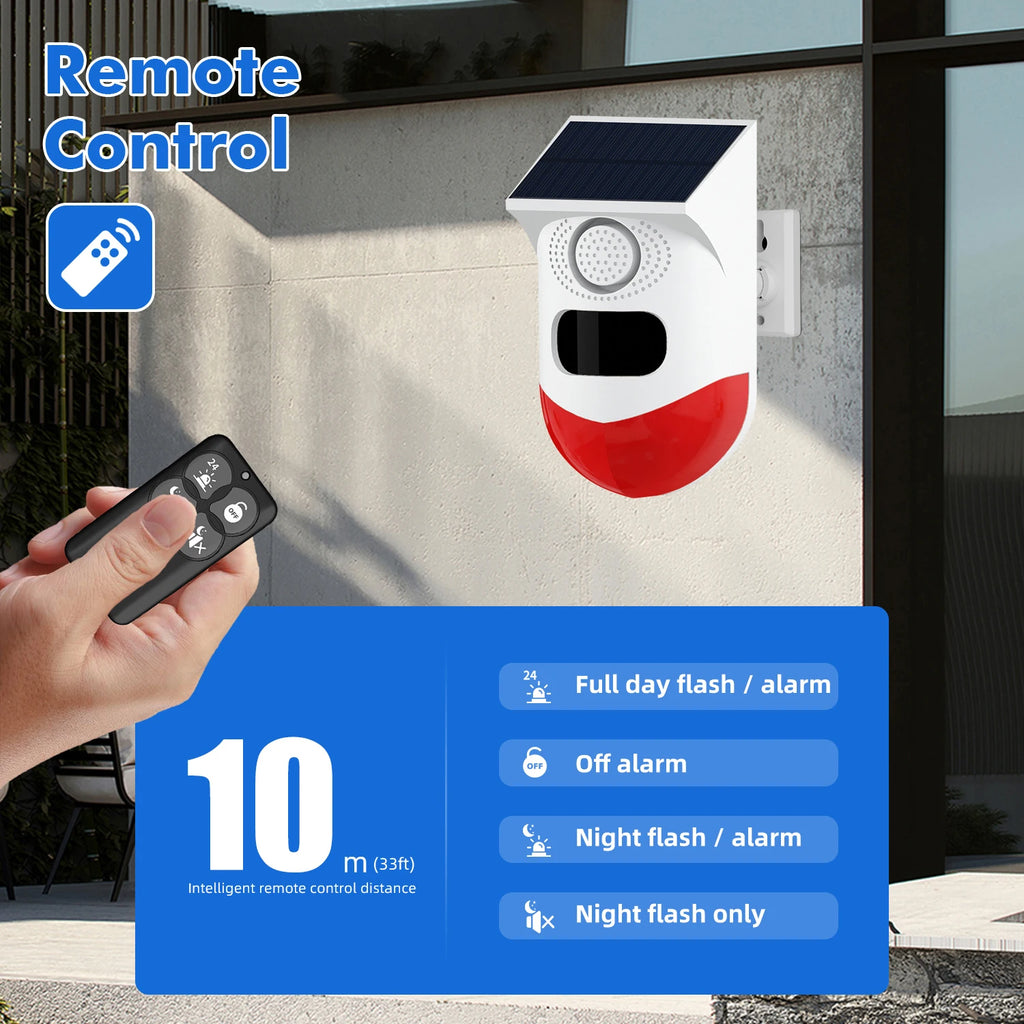 White and red solar-powered wireless motion security alarm mounted on a wall, shown with a handheld remote control.