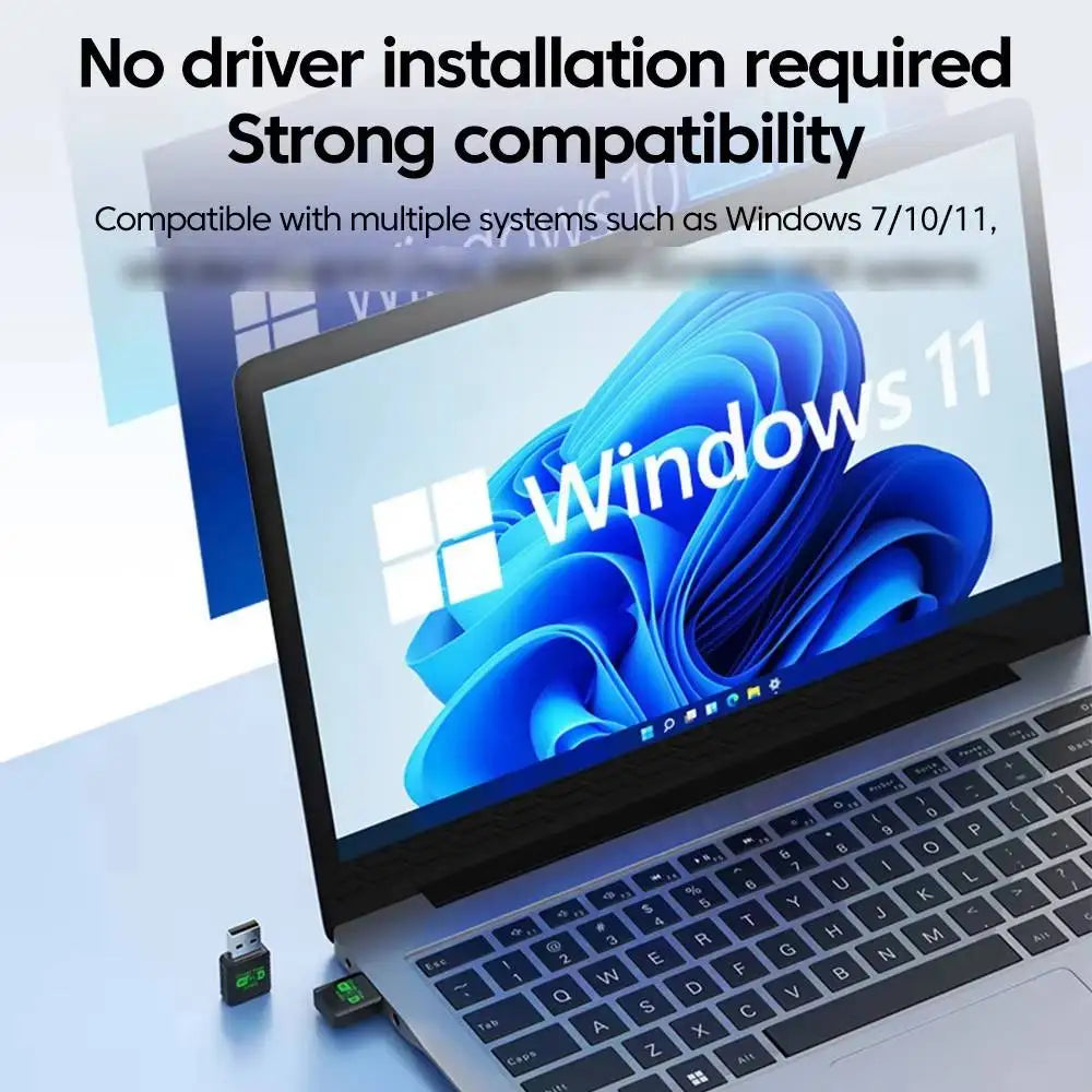 Small black USB WiFi 6 and Bluetooth 5.4 adapter plugged into a silver laptop, displaying Windows 11 compatibility.