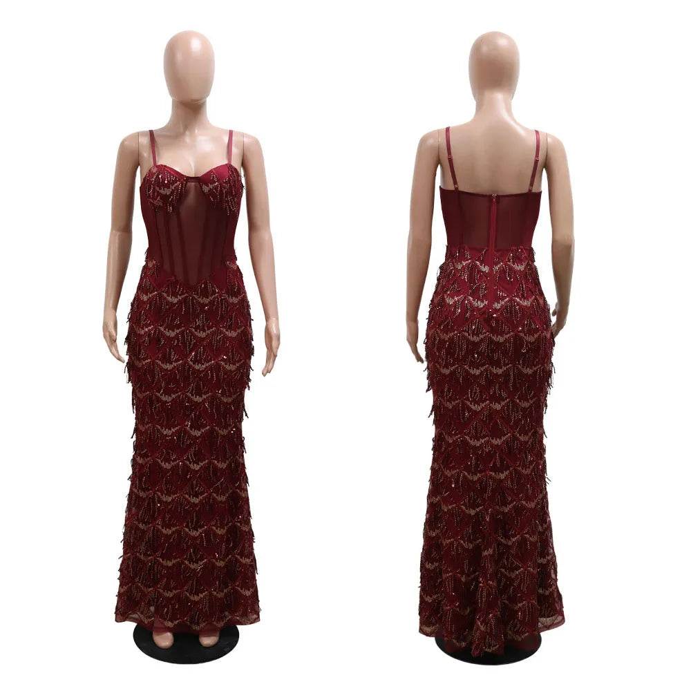Burgundy spaghetti strap maxi dress featuring a sheer corset bodice and sequined fringe detailing.
