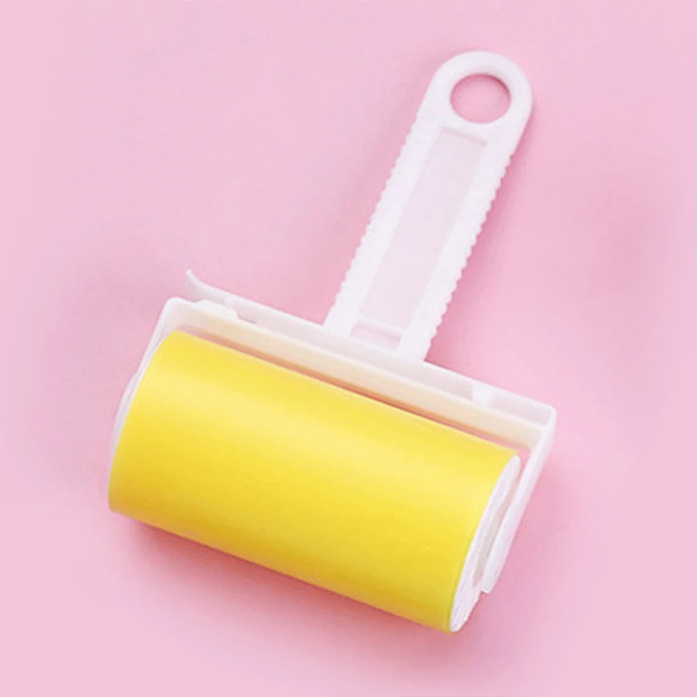 Lint roller with a bright yellow adhesive roll and white plastic handle, isolated on a pale pink background.