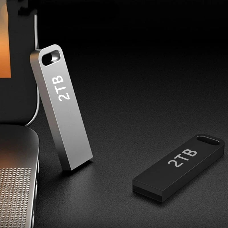 Two portable 2TB flash drives in silver and black, featuring a sleek, minimalist design with a keyring hole.