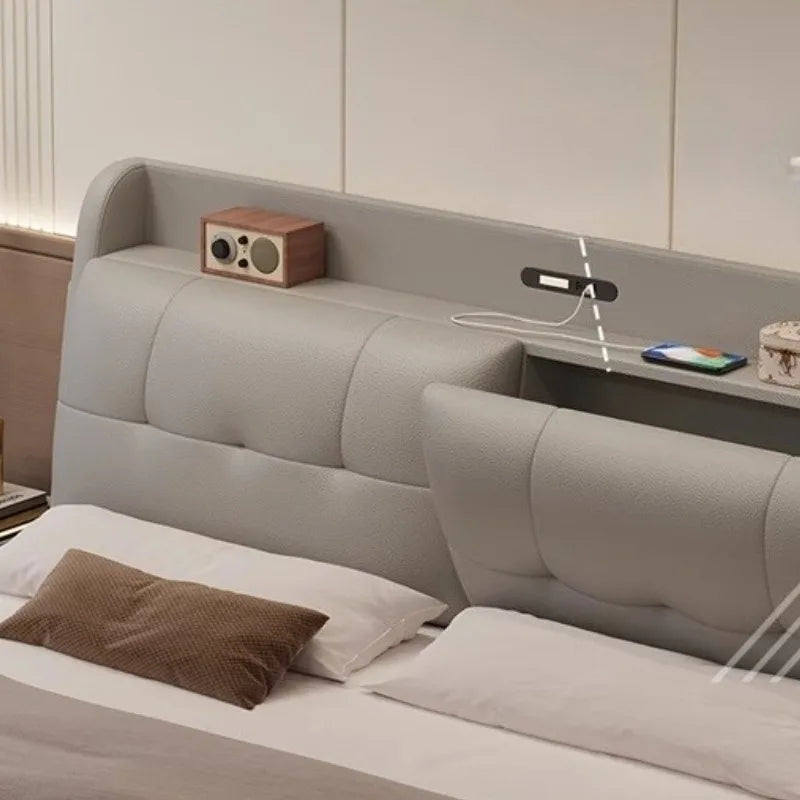 Modern cream upholstered bed featuring a tufted headboard with integrated storage shelf and built-in USB charging ports.