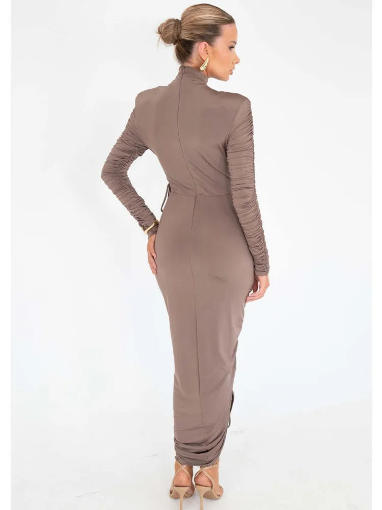 Brown long-sleeve maxi dress with a high neck, ruching on sleeves, and slim, fitted silhouette.