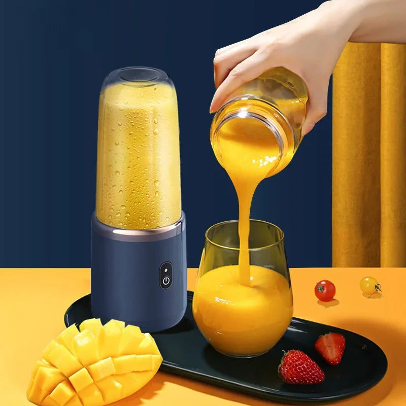 Portable navy blue blender pouring a yellow smoothie into a glass next to mango and strawberries.