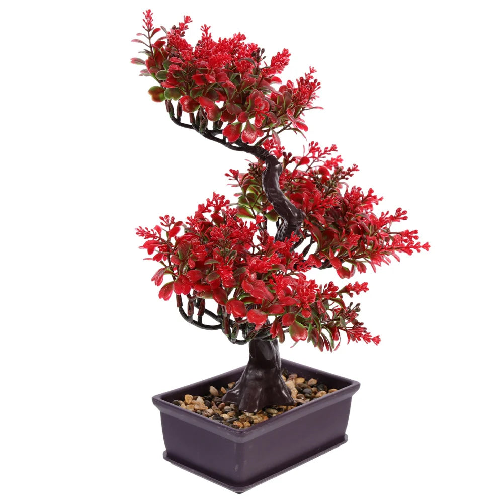 Artificial bonsai tree with bright red leaves in a rectangular dark pot filled with decorative pebbles.
