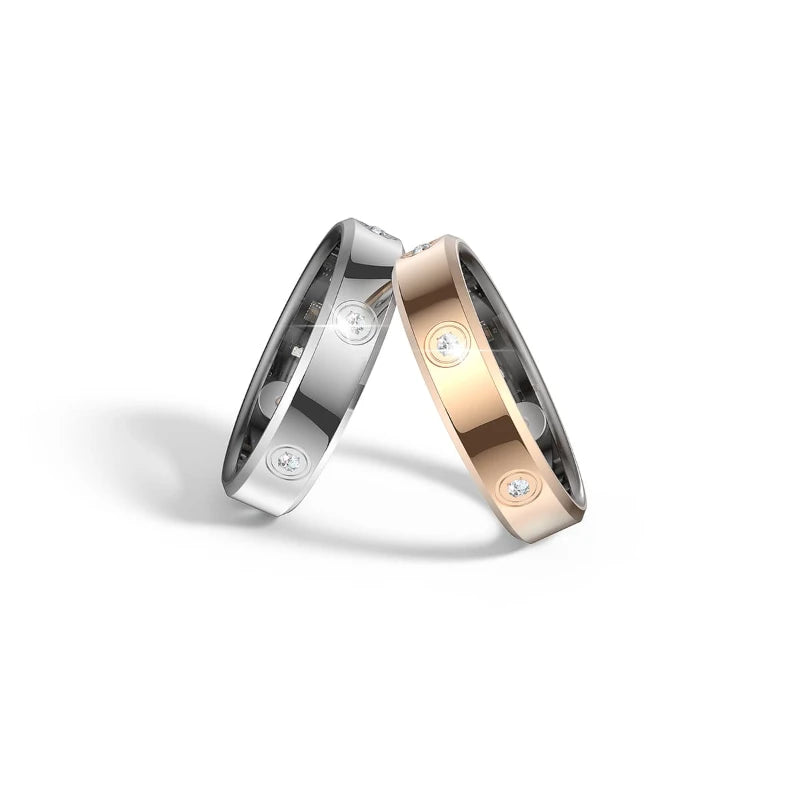 Two slim smart fitness tracking rings in silver and rose gold, featuring embedded crystals and a sleek metal finish.