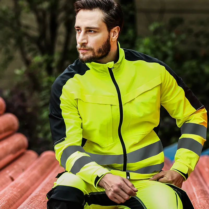 Man wearing a neon yellow and black high-visibility work jacket with reflective strips and a front zipper.