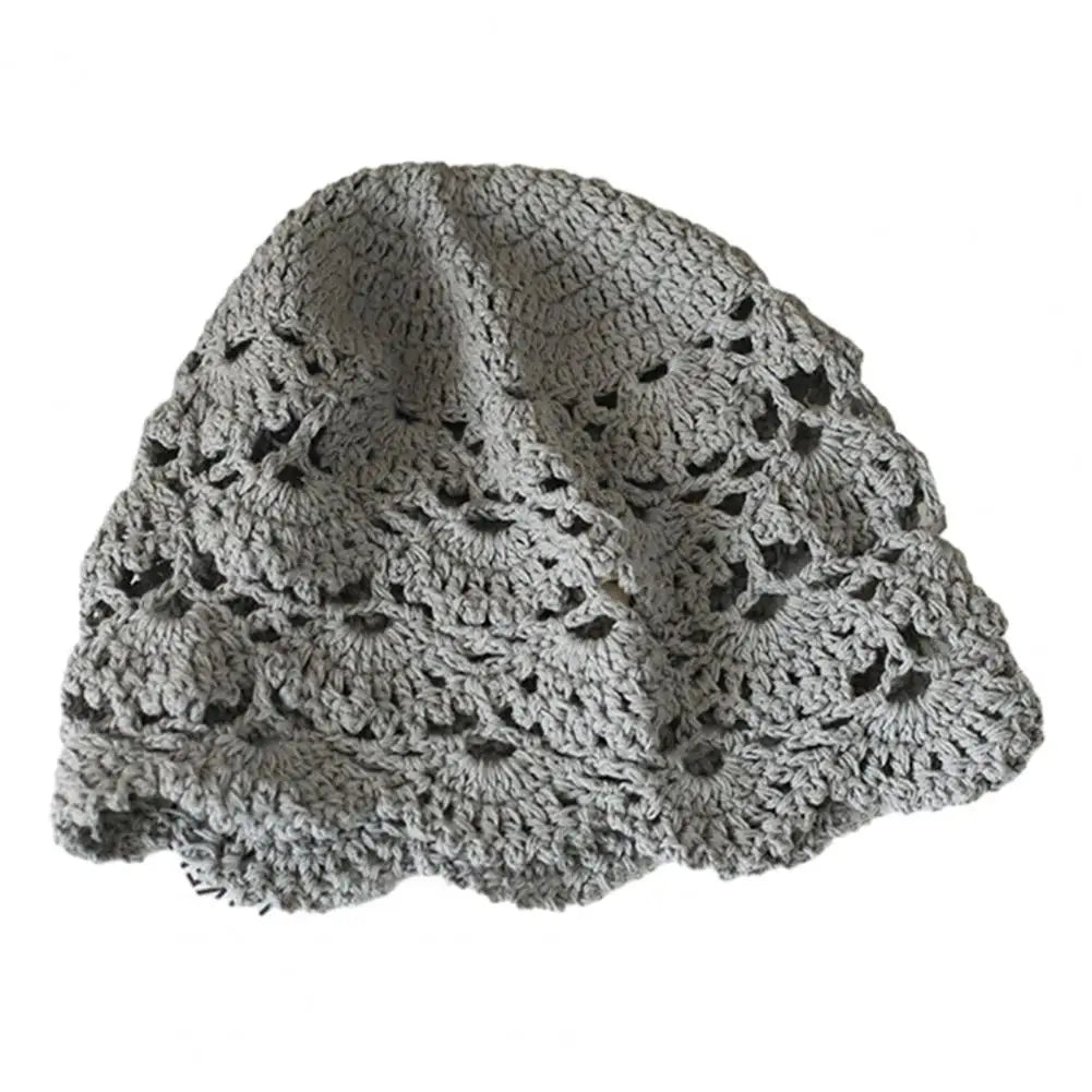 Grey crochet hat in a hollow, scalloped lace pattern with a soft, rounded fit.