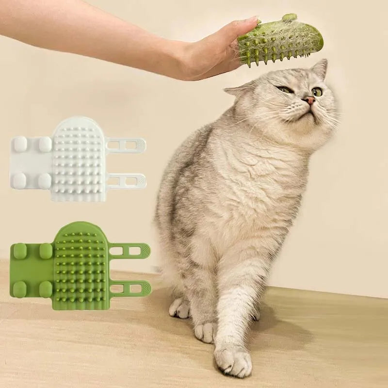 Hand held white and green silicone cat grooming brushes with spiky texture shown in use on a grey cat.