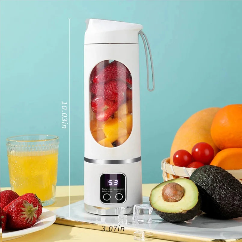 Portable white personal blender with a digital display, filled with fruit, next to fresh produce on a table.