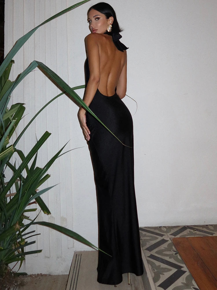 Black sleeveless halter neck bodycon maxi dress with an open back and tie closure.