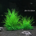 Two vibrant, neon-green artificial aquarium grass plants in a dark fish tank with gravel and small fish.