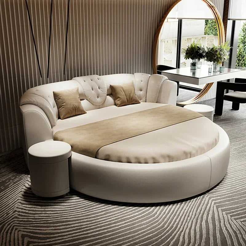 Modern white circular luxury double bed with tufted headboard, cream accents, and a matching bedside stool.