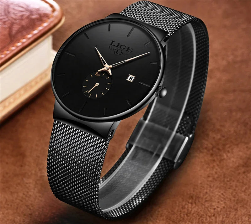 Elegant ultra-thin women’s watch with a black dial, gold hands, and a sleek black stainless steel mesh strap.