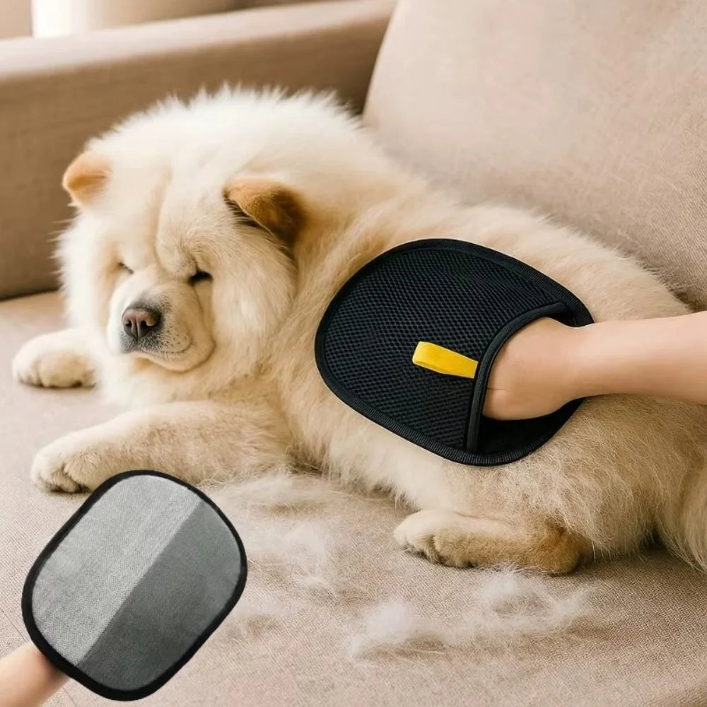 Black pet grooming mitt with yellow tab, shown in use on a fluffy cream Chow Chow dog on a sofa.