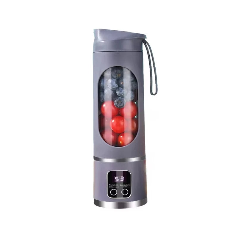 Grey portable blender with a digital display, transparent central window, and carry strap, filled with fruit.