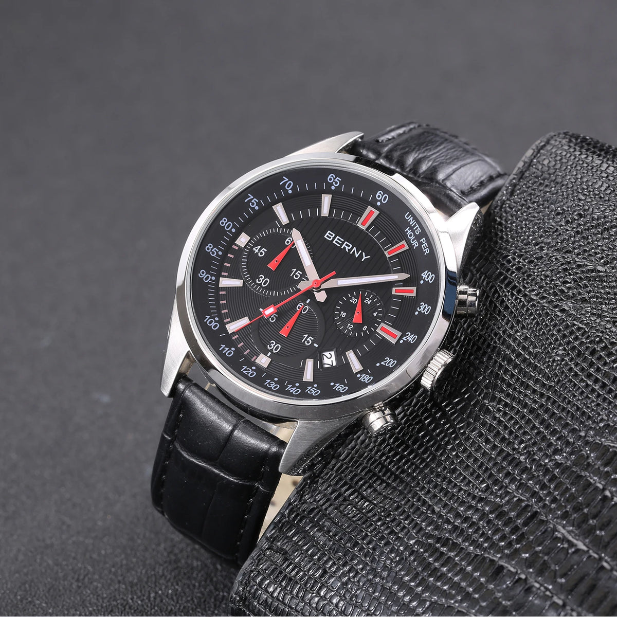 BERNY men's chronograph watch with round silver case, black dial, tachymeter bezel, and black leather strap.