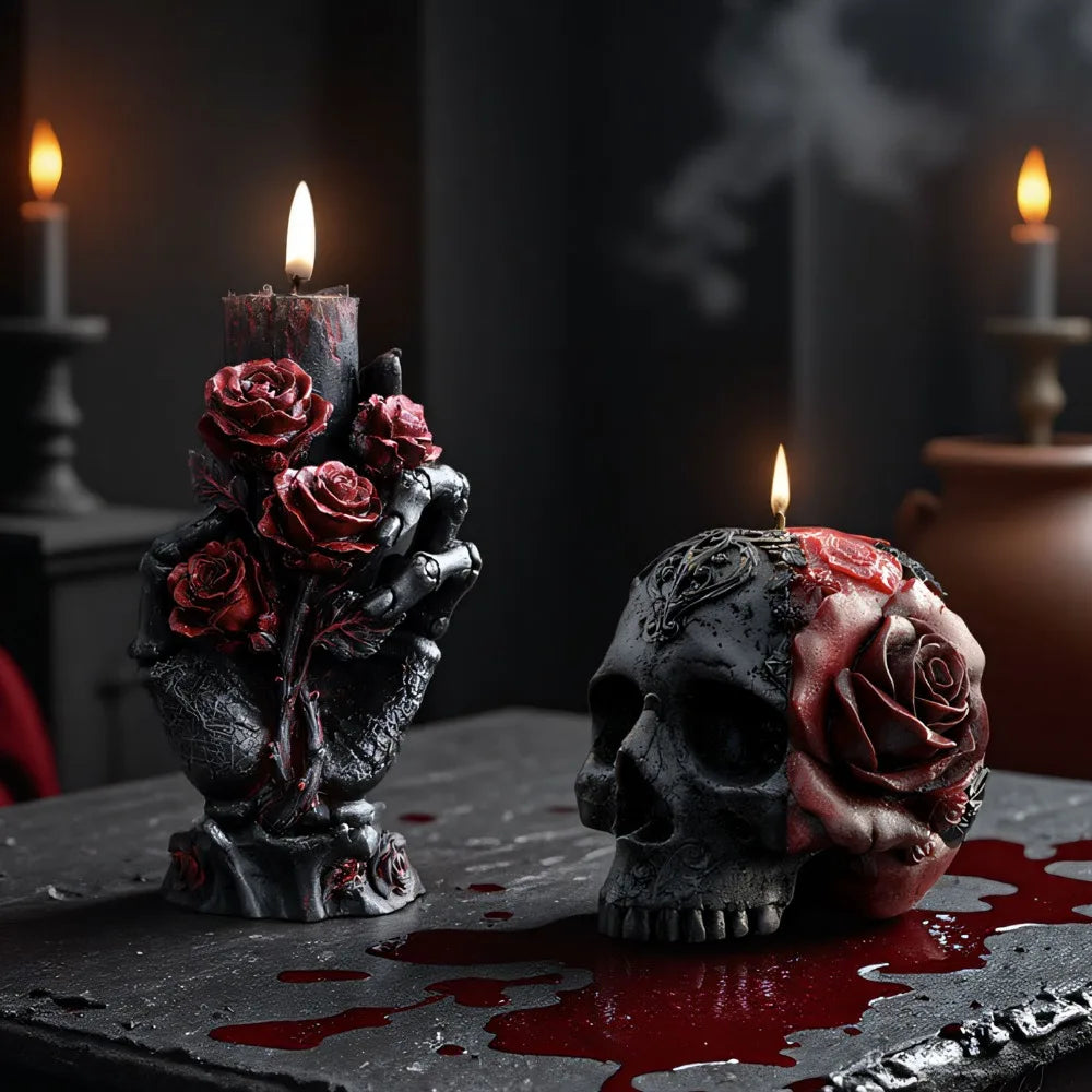 Black skeleton hand candle holding red roses, and a gothic skull candle with a red rose design.