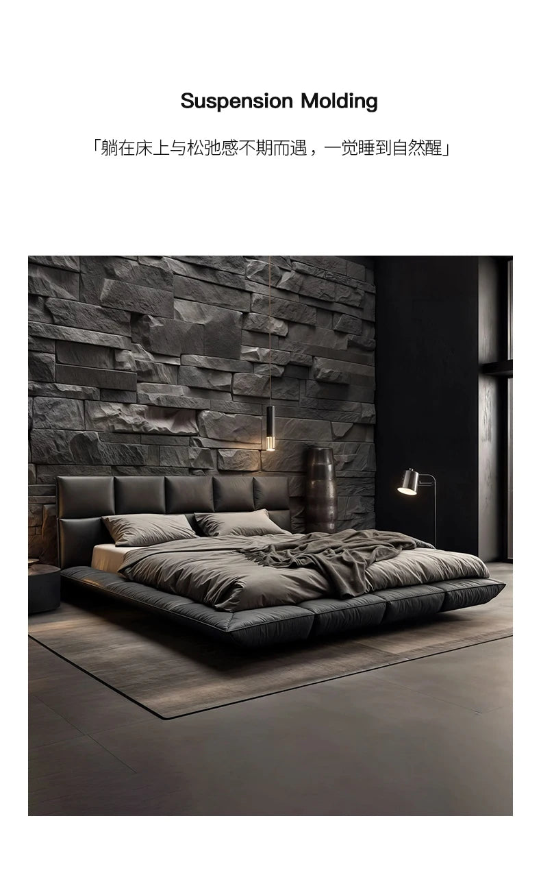 Modern king-size floating leather bed in charcoal grey, featuring a wide, upholstered headboard in a dark bedroom.