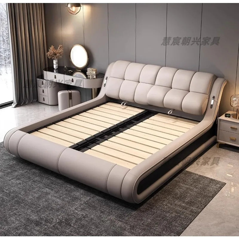 Modern, low-profile bed frame in light grey leather with a cushioned, tufted headboard and wooden slatted base.