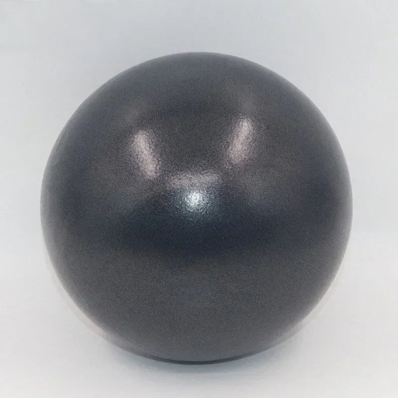 A smooth, matte charcoal-grey yoga or Pilates exercise ball isolated against a plain white background.