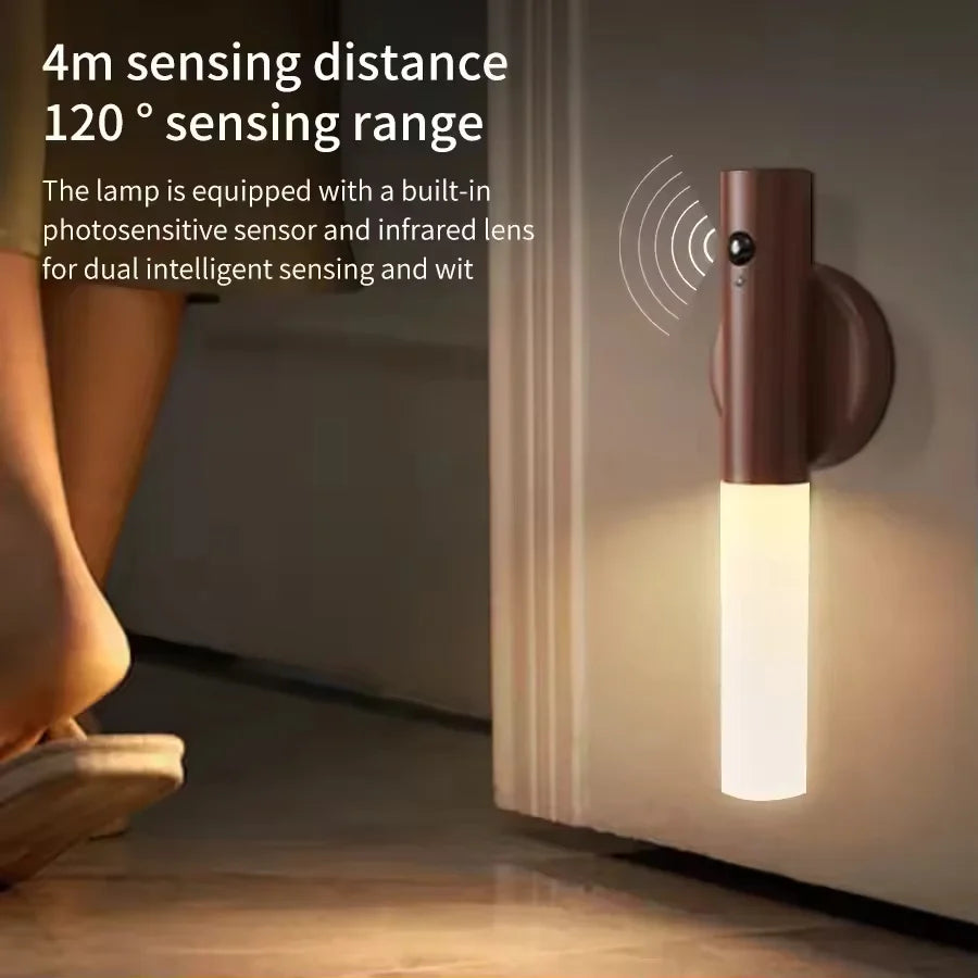 Wall-mounted, dark brown rechargeable LED night light with motion sensor glowing softly by a door.