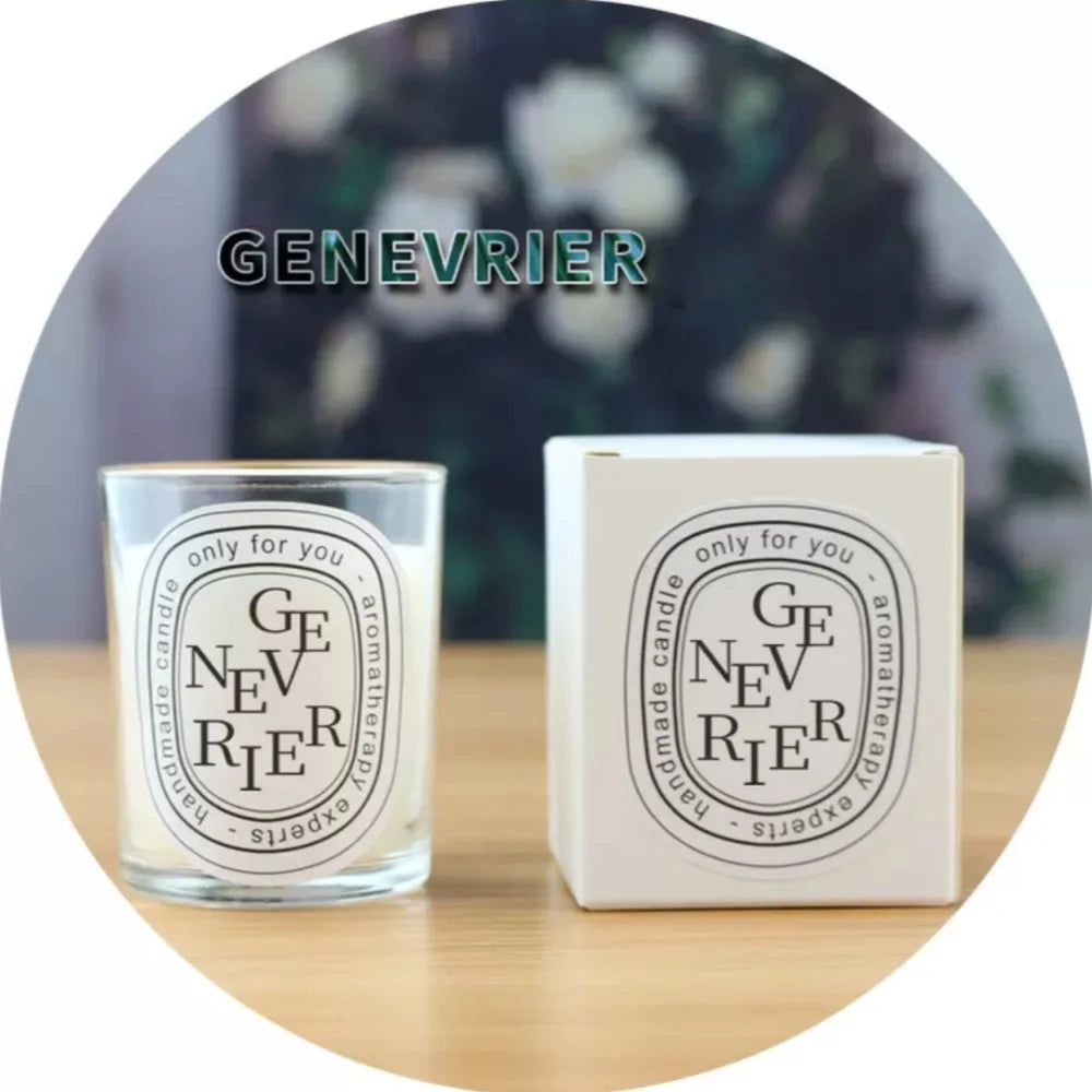 A clear glass aromatherapy candle next to its white matching gift box on a wooden surface.