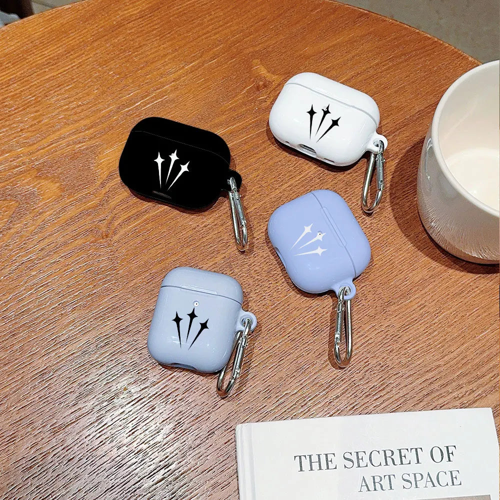 Four silicone AirPods cases in black, white, and lilac, each featuring a star print and a silver carabiner clip.