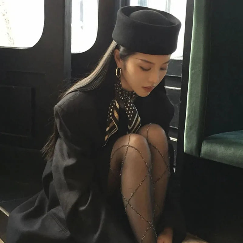 Elegant black wool Hepburn-style hat with a structured, rounded crown and a short, flat brim.