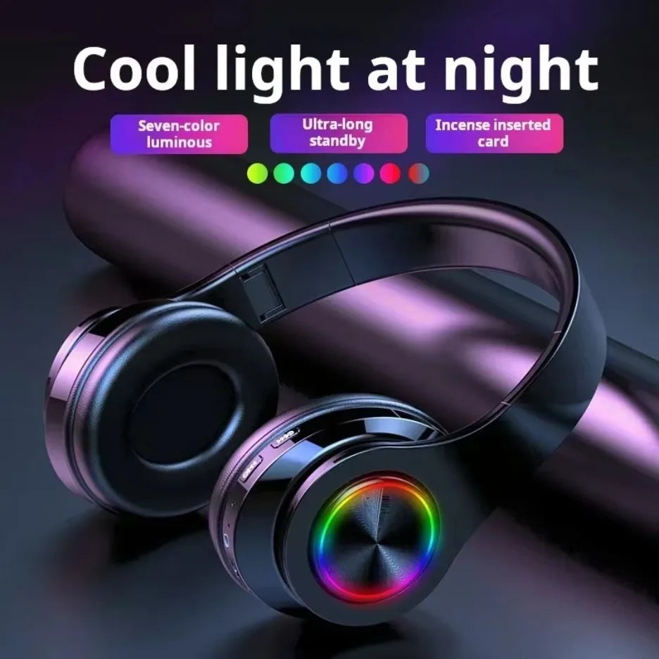 Wireless over-ear gaming headphones in dark metallic finish, featuring multi-coloured circular LED lights on ear cups.