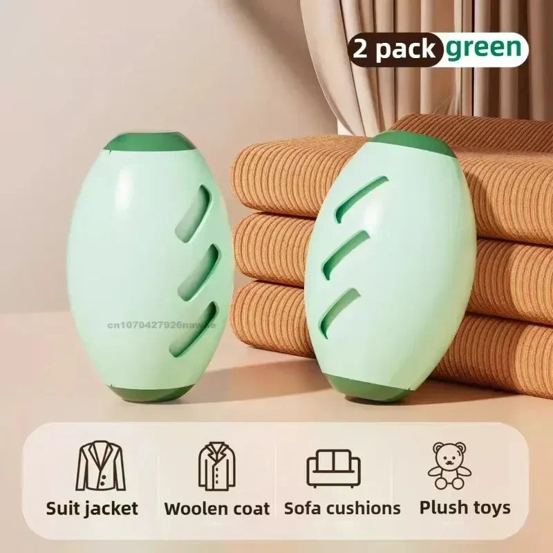 A 2-pack of oval, sage-green fabric lint removers with slanted slots, shown against folded brown fabric.