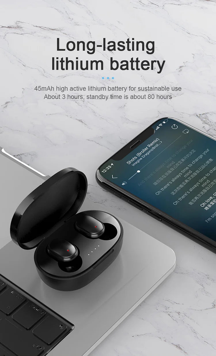 Black wireless earbuds in an open charging case next to a smartphone showing a music app on a marble background.