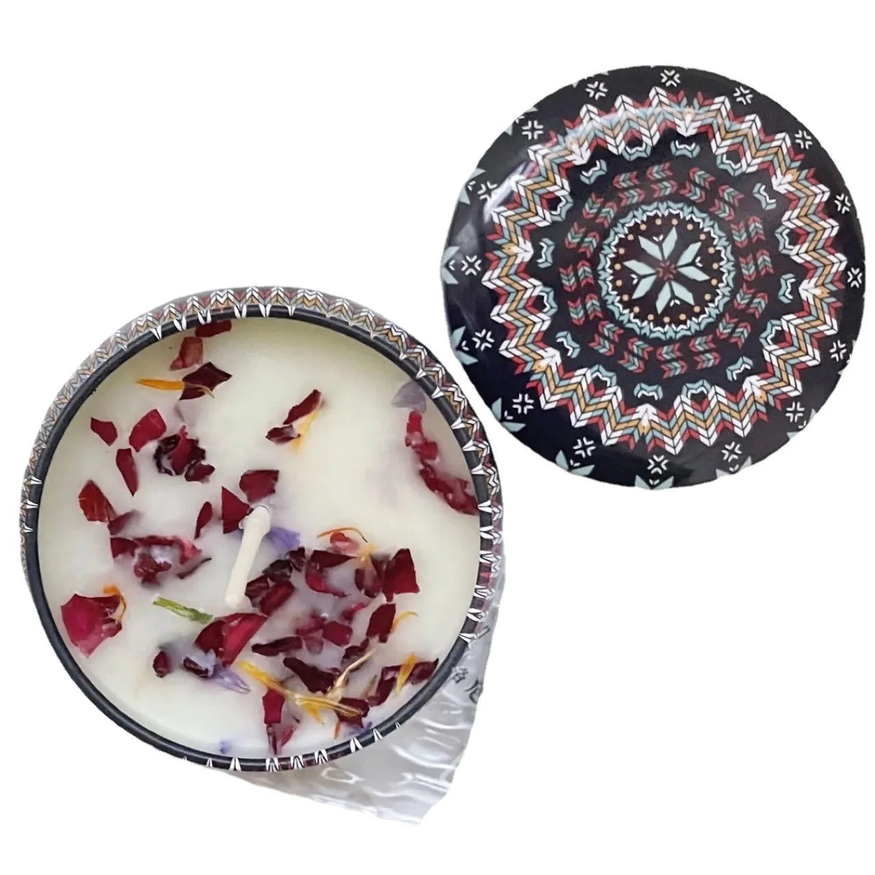 Scented candle in a patterned metal tin with a geometric lid, featuring white wax topped with dried flower petals.