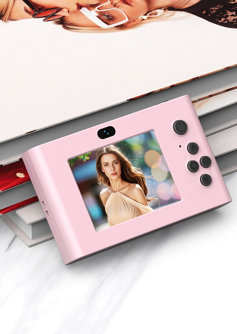 Pink plastic digital camera with a rear screen displaying a photo, camera lens, and four control buttons on the side.