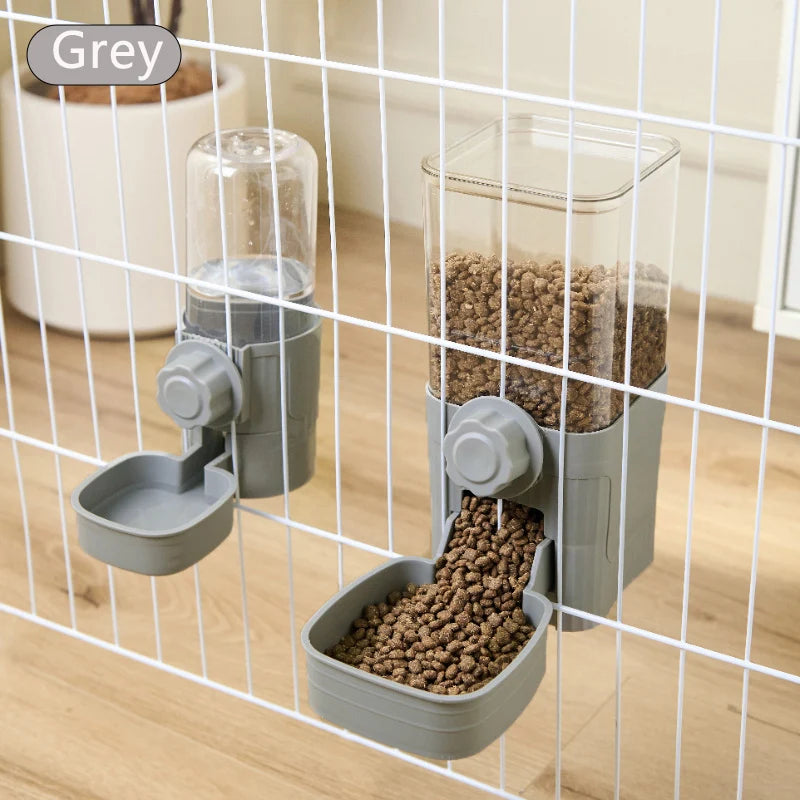 Grey wall-mounted pet food and water dispensers with clear plastic containers, attached to a wire cage.