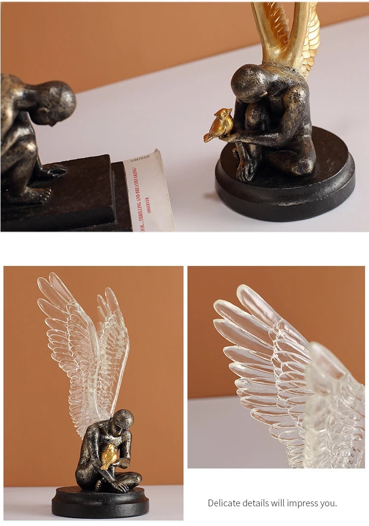 Decorative figurine of a winged, weathered-bronze figure holding a small gold bird, featuring clear glass wings.
