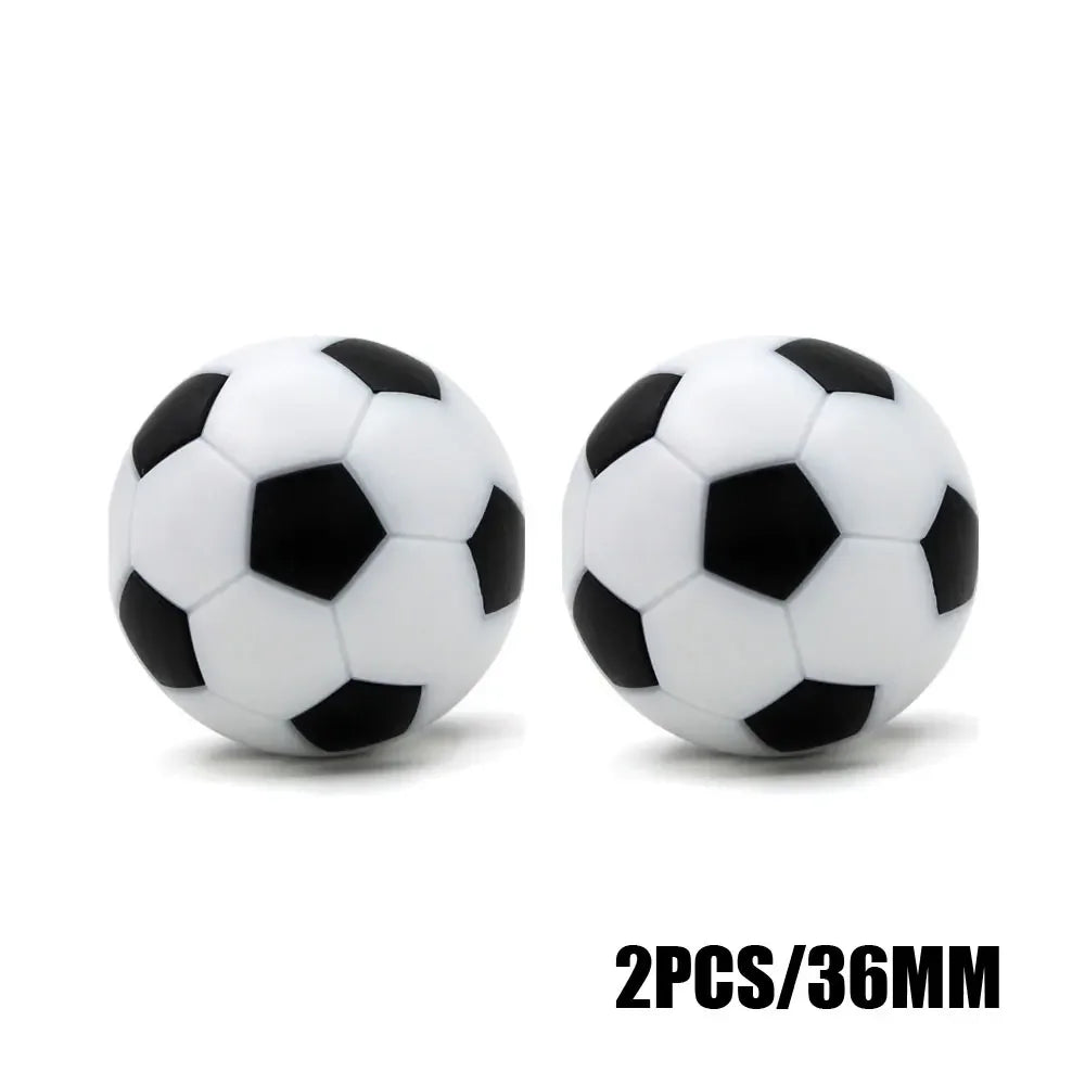 Two 36mm black and white football-style table soccer balls isolated on white.