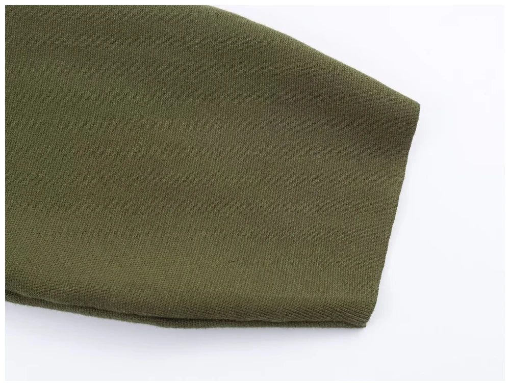 Close-up of a plain olive green knitted sleeve with a clean, folded hem.