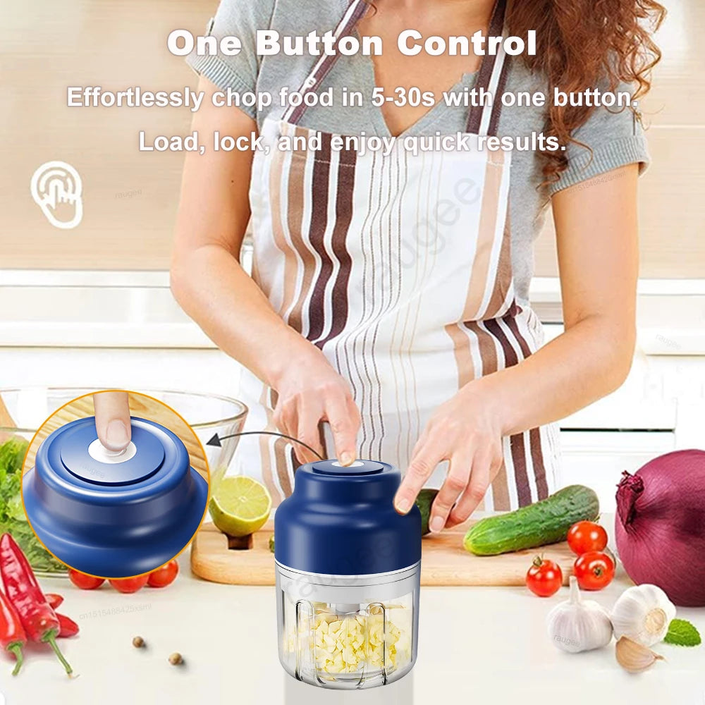A person using a compact, blue-and-clear electric food chopper on a kitchen counter with fresh vegetables.