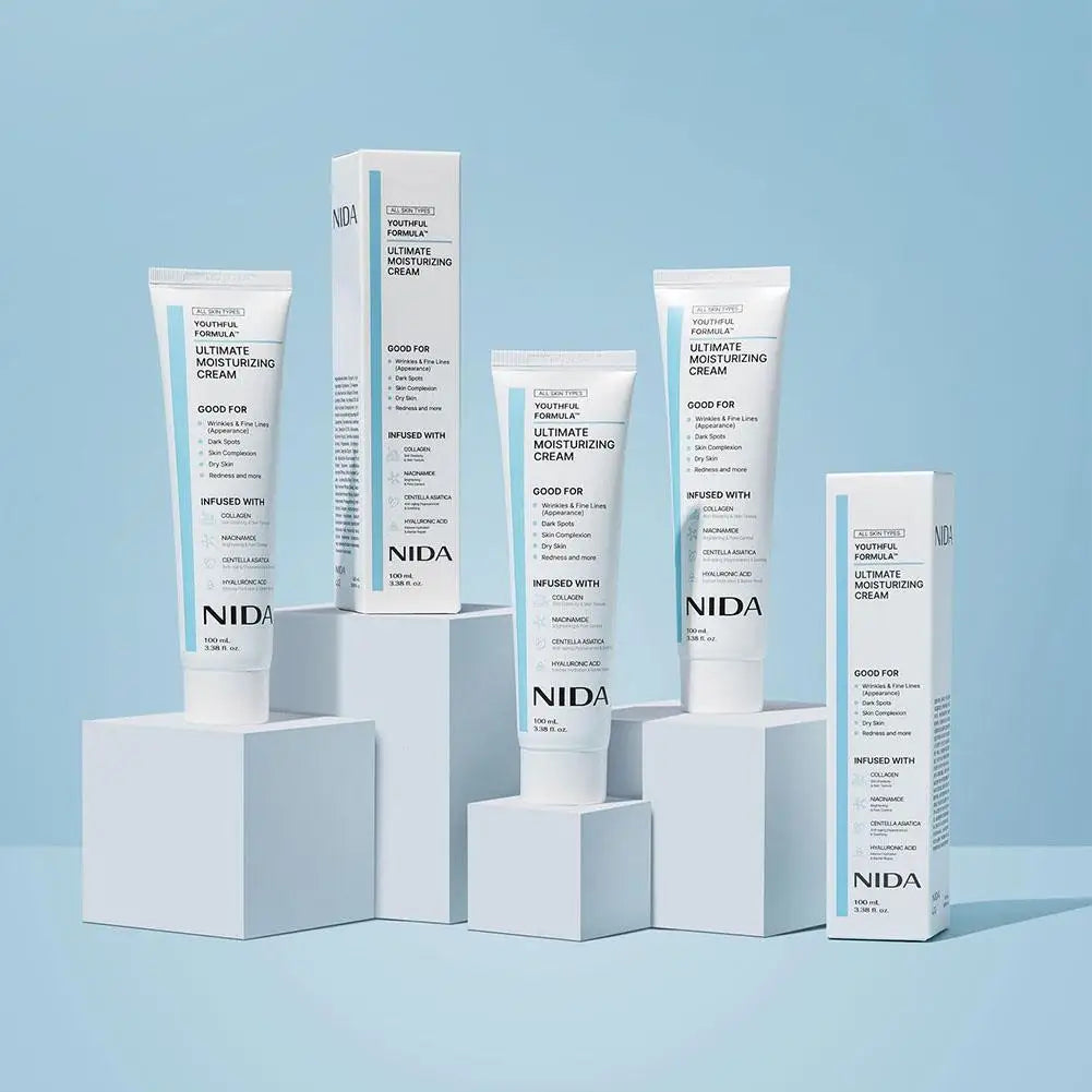 Three white tubes and two boxes of Ultimate Moisturizing Cream displayed on white blocks against a light blue background.
