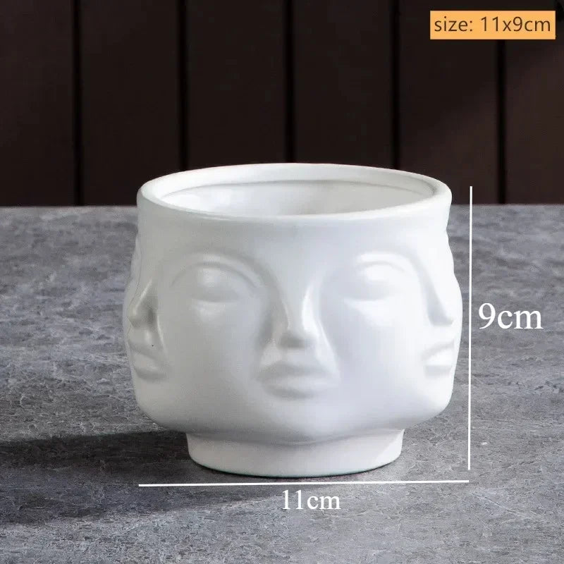 White ceramic planter bowl featuring an embossed multi-face design, 11cm diameter by 9cm height.