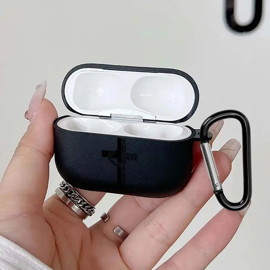 Black silicone AirPods Pro case with cross design and black carabiner, held in a hand.