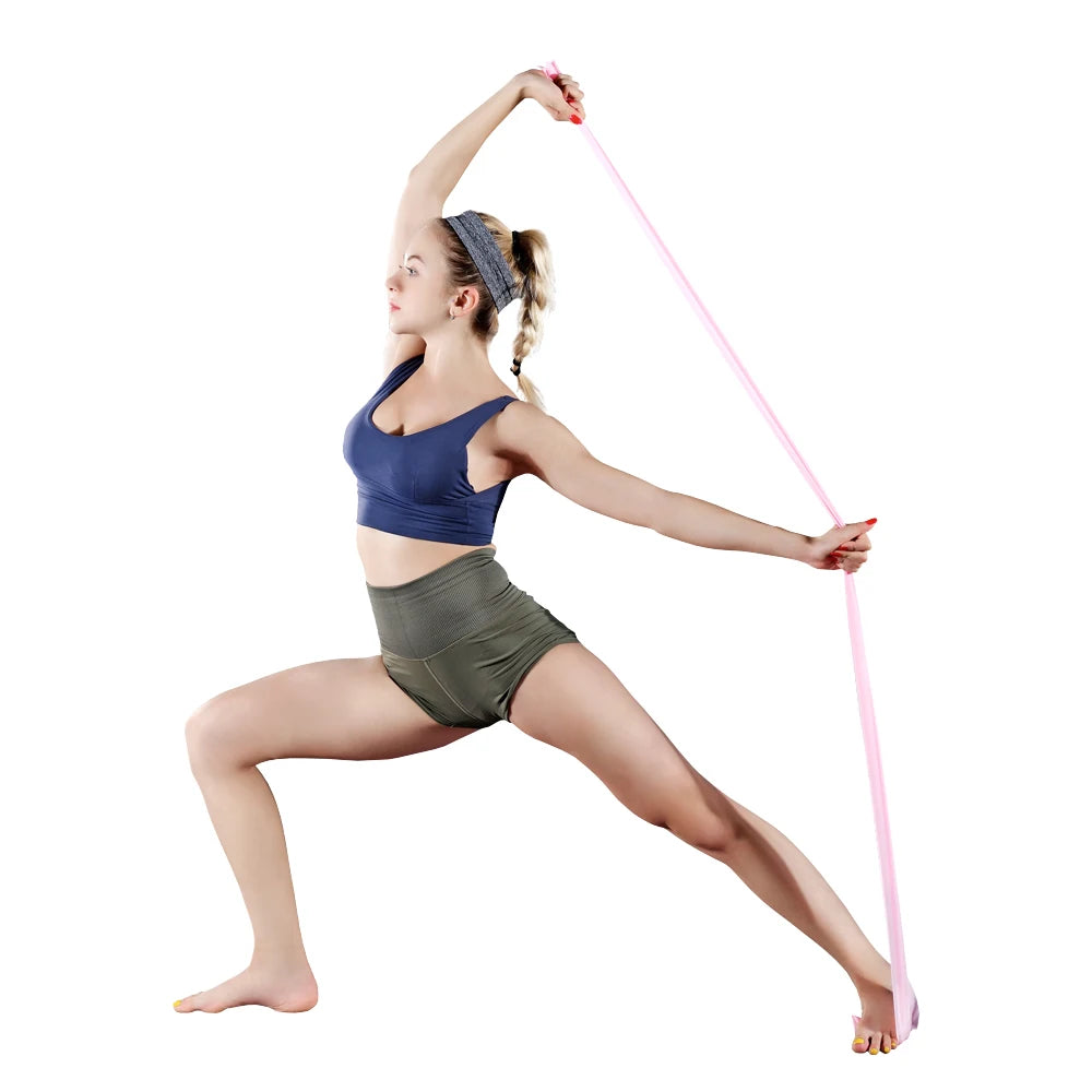 A woman in sportswear using a long pink resistance band while doing a lunge exercise. Isolated on white background.