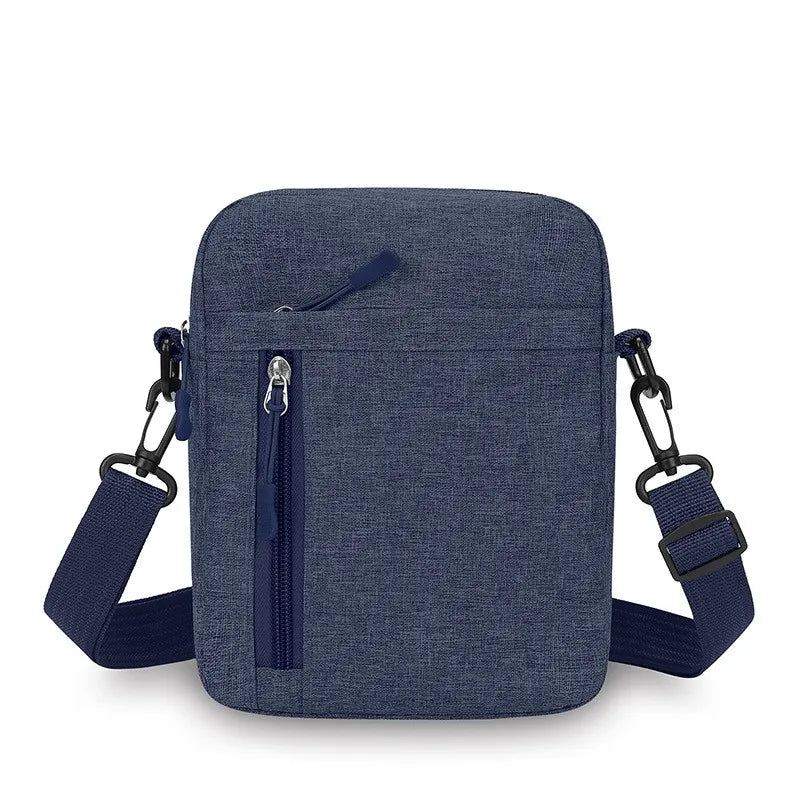 A navy blue fabric crossbody bag featuring an adjustable shoulder strap and a vertical front zip pocket.