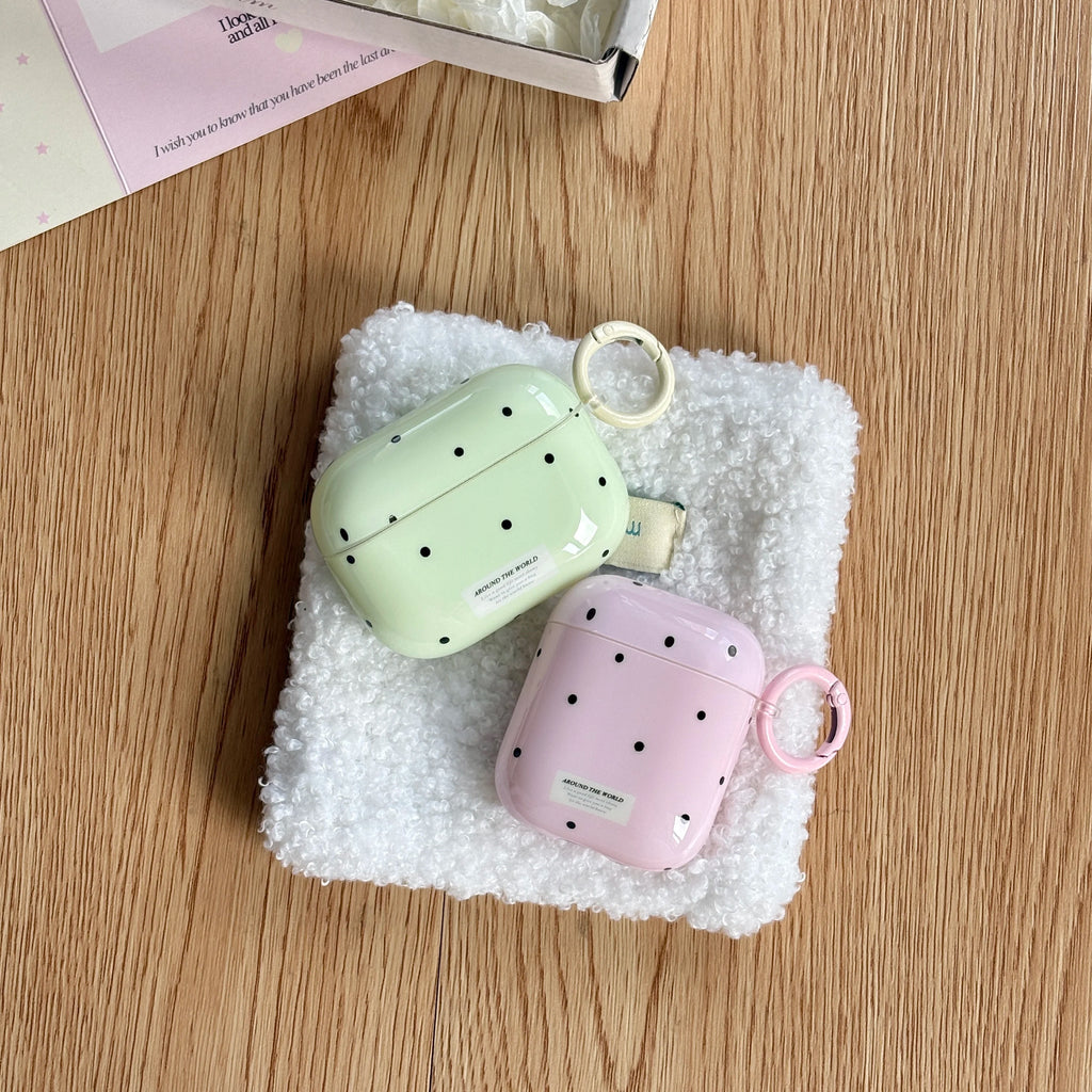 Glossy polka-dot AirPods Pro and 1/2 cases in pastel green and pink, featuring matching ring clips on a fleece base.